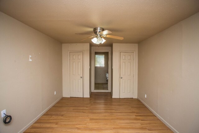 unfurnished bedroom featuring ceiling fan, light hardwood / wood-style floors, and a textured ceiling