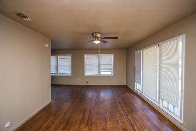 unfurnished room with dark hardwood / wood-style flooring, ceiling fan, and a healthy amount of sunlight