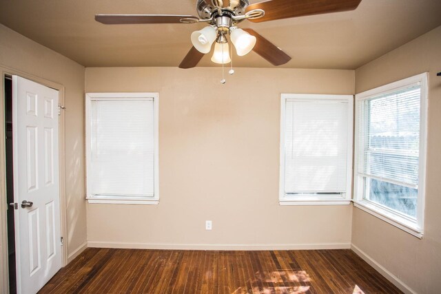 spare room with ceiling fan, a healthy amount of sunlight, and dark hardwood / wood-style flooring