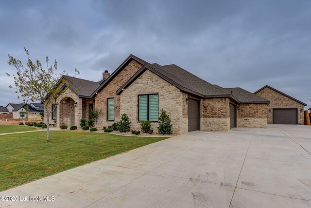 7726 46th St, Lubbock, TX 79407 - view of front facade with a garage, concrete driveway, stone siding, a chimney, and a front yard
