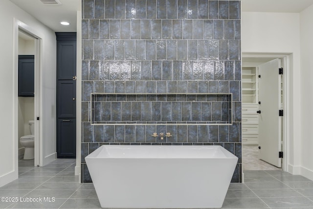 7726 46th St, Lubbock, TX 79407 - full bathroom featuring a freestanding tub, tile patterned floors, recessed lighting, tile walls, and a closet