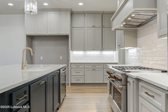 7726 46th St, Lubbock, TX 79407 - kitchen with double oven range, premium range hood, recessed lighting, light wood-style flooring, and decorative backsplash