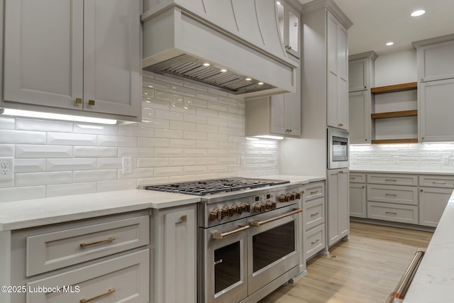7726 46th St, Lubbock, TX 79407 - kitchen with appliances with stainless steel finishes, custom exhaust hood, gray cabinets, open shelves, and tasteful backsplash