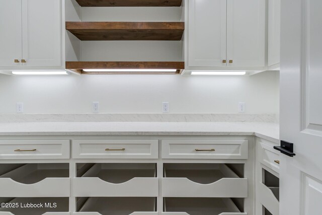 7726 46th St, Lubbock, TX 79407 - kitchen with white cabinetry, open shelves, and light stone countertops