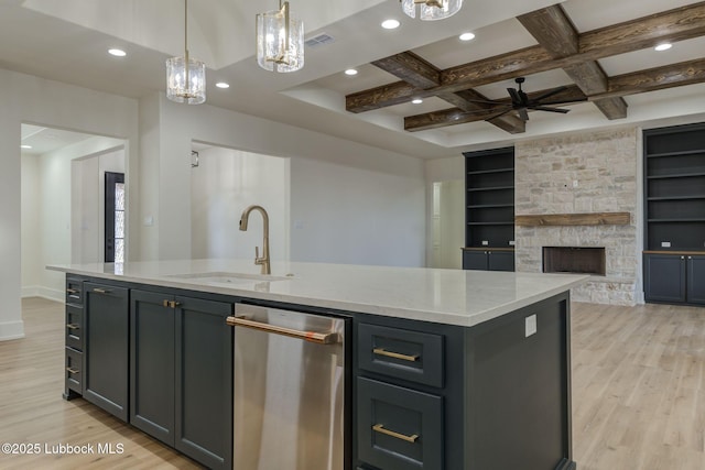 7726 46th St, Lubbock, TX 79407 - kitchen with light wood-type flooring, open floor plan, light stone countertops, an island with sink, and a fireplace
