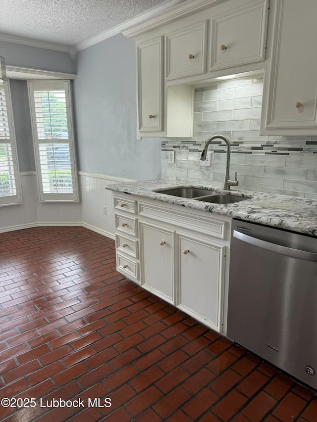 3506 97th St, Lubbock, TX 79423 - kitchen with dishwasher, a sink, a textured ceiling, brick flooring, and wainscoting