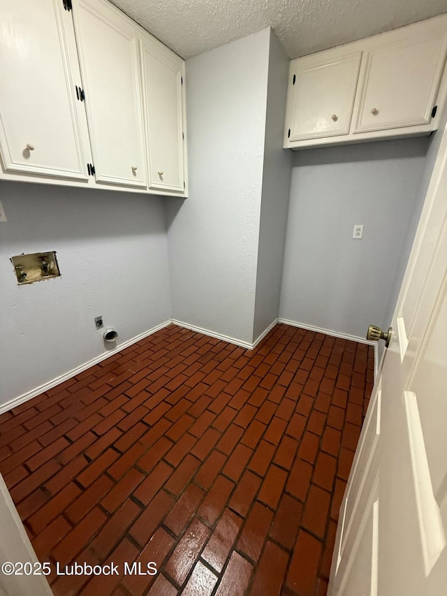 3506 97th St, Lubbock, TX 79423 - washroom featuring washer hookup, cabinet space, baseboards, electric dryer hookup, and a textured ceiling