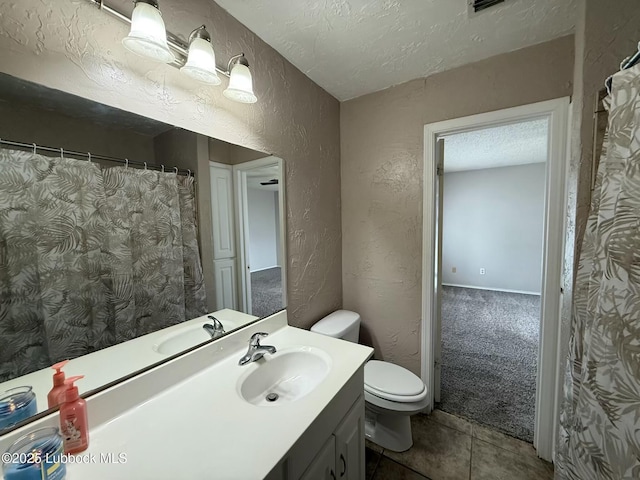 3506 97th St, Lubbock, TX 79423 - bathroom featuring a textured wall, toilet, vanity, a textured ceiling, and tile patterned flooring