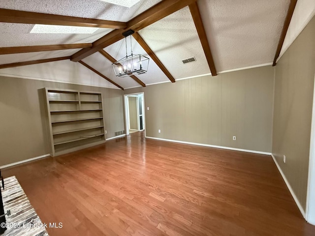 3506 97th St, Lubbock, TX 79423 - unfurnished living room featuring a chandelier, wood finished floors, baseboards, a textured ceiling, and a skylight