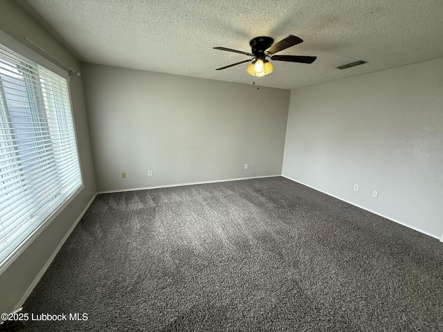 3506 97th St, Lubbock, TX 79423 - spare room with dark carpet, a ceiling fan, a textured ceiling, and baseboards