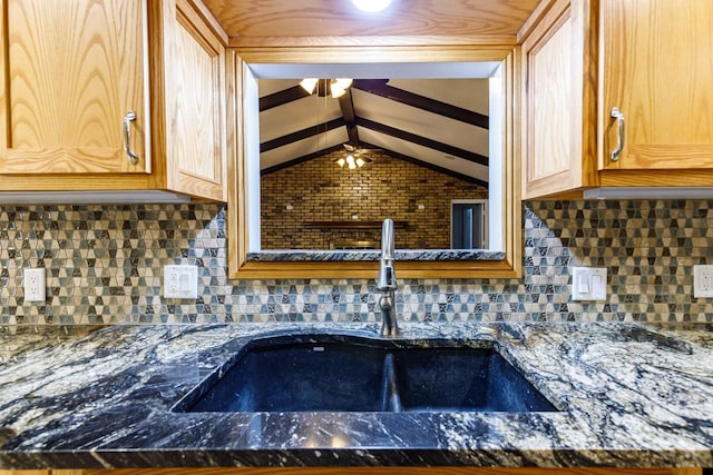 details with dark stone countertops, sink, and tasteful backsplash