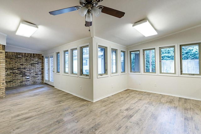 empty room featuring crown molding, lofted ceiling, and light hardwood / wood-style floors