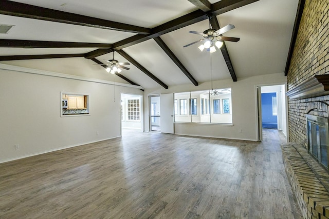 unfurnished living room featuring lofted ceiling with beams, a brick fireplace, dark wood-type flooring, and ceiling fan