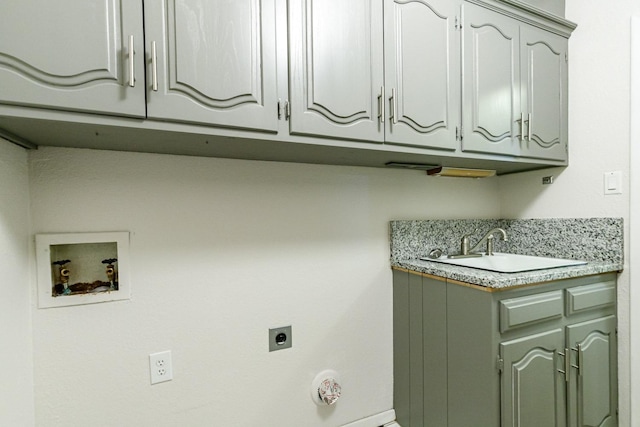 laundry area featuring electric dryer hookup, sink, hookup for a washing machine, and cabinets