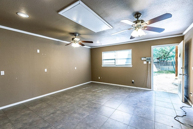 unfurnished room featuring dark tile patterned flooring, ornamental molding, a textured ceiling, and ceiling fan