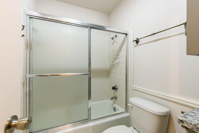 bathroom featuring shower / bath combination with glass door and toilet