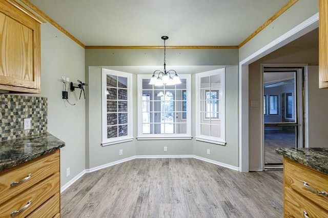 unfurnished dining area featuring hardwood / wood-style flooring, ornamental molding, and a chandelier