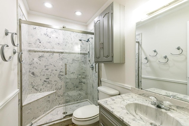 bathroom with ornamental molding, vanity, toilet, and a shower with shower door