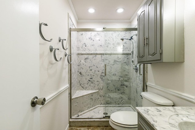 bathroom featuring ornamental molding, toilet, an enclosed shower, and vanity