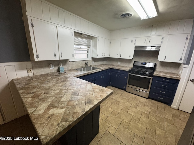 2721 52nd St, Lubbock, TX 79413 - kitchen with stainless steel gas range oven, under cabinet range hood, blue cabinets, a sink, and white cabinets