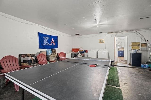 recreation room with separate washer and dryer and concrete floors