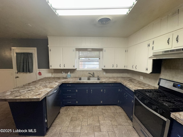 2721 52nd St, Lubbock, TX 79413 - kitchen with under cabinet range hood, blue cabinets, a sink, a peninsula, and stainless steel appliances