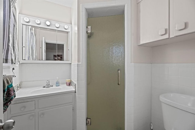 bathroom featuring tile walls, vanity, toilet, and walk in shower