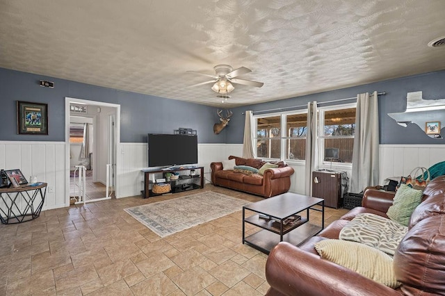 living room featuring a textured ceiling and ceiling fan