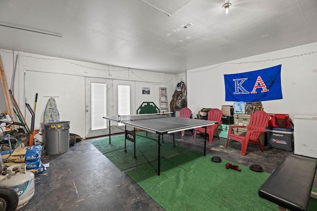 recreation room featuring concrete flooring and french doors