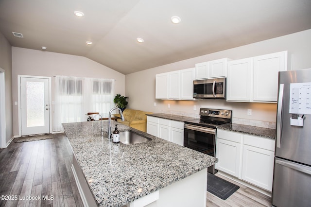 10422 Waverly Ave, Lubbock, TX 79424 - kitchen with appliances with stainless steel finishes, lofted ceiling, white cabinets, light stone countertops, and wood finished floors