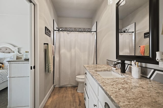 bathroom featuring hardwood / wood-style flooring, vanity, a shower with shower curtain, and toilet