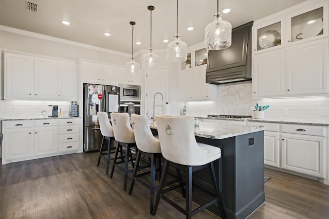 kitchen featuring white cabinetry, hanging light fixtures, a center island with sink, custom range hood, and stainless steel appliances