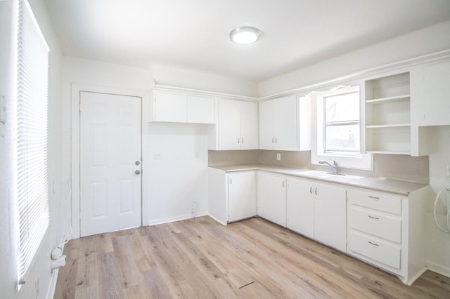 kitchen with white cabinetry, sink, and light hardwood / wood-style floors