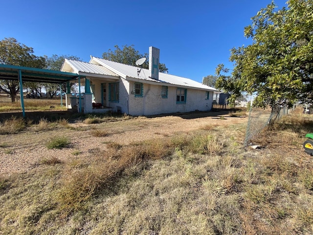 back of house featuring a carport