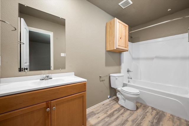 full bathroom with vanity, hardwood / wood-style floors, shower / bathtub combination, and toilet