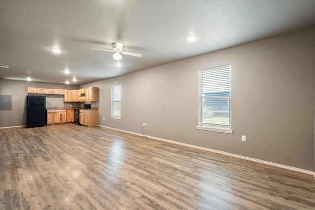 unfurnished living room featuring hardwood / wood-style flooring, ceiling fan, and electric panel