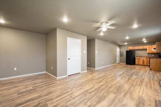 unfurnished living room featuring ceiling fan and light wood-type flooring