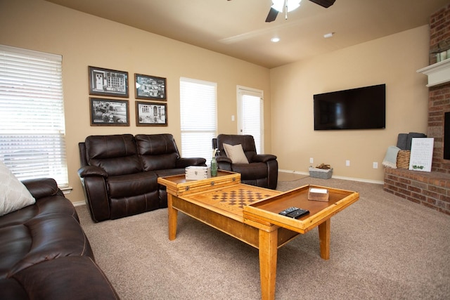 carpeted living room with a wealth of natural light, a fireplace, and ceiling fan