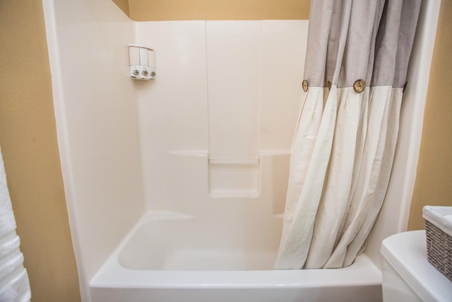 bathroom featuring shower / bathtub combination with curtain and toilet