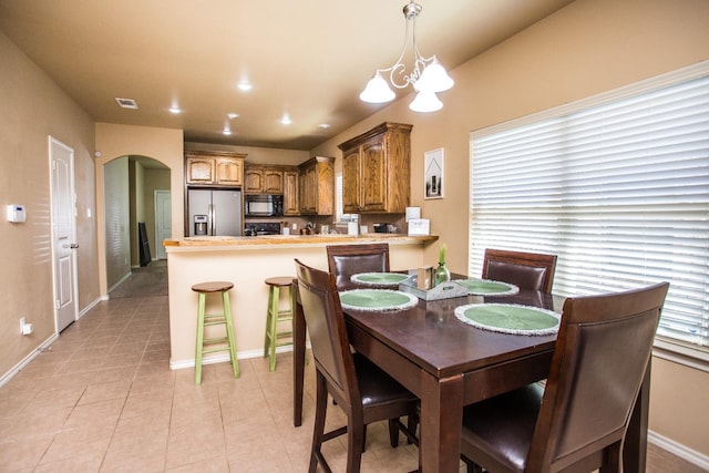 tiled dining area with an inviting chandelier