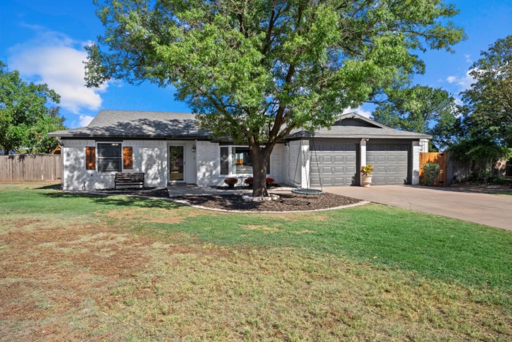 ranch-style home with a garage and a front yard