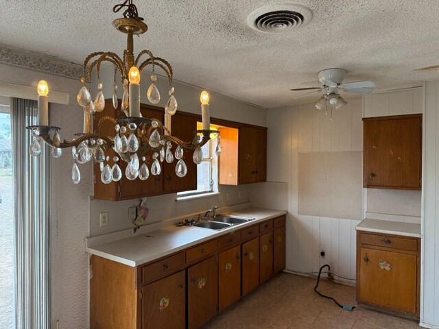 kitchen with sink, pendant lighting, a textured ceiling, and ceiling fan