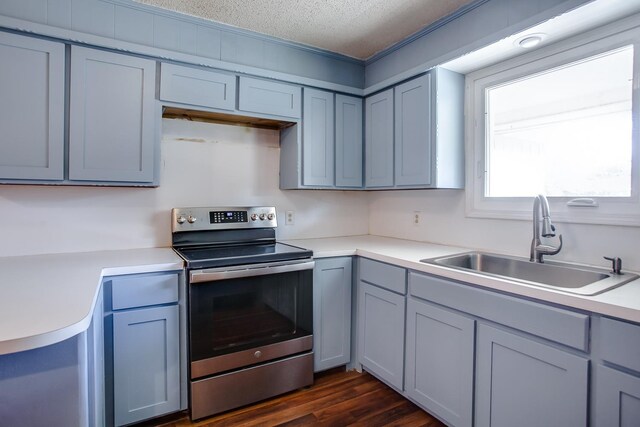 kitchen with gray cabinets, sink, stainless steel range with electric stovetop, dark wood-type flooring, and a textured ceiling