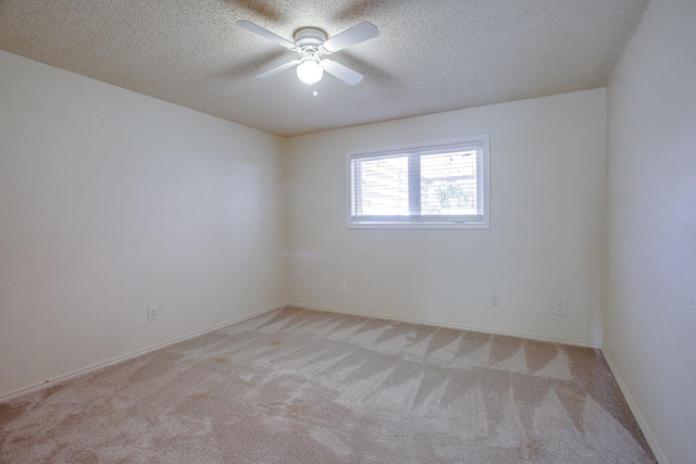 spare room featuring ceiling fan, light colored carpet, and a textured ceiling