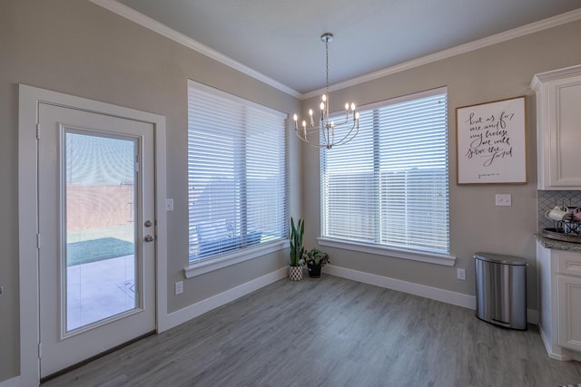 dining area with light wood-style flooring, baseboards, an inviting chandelier, and ornamental molding