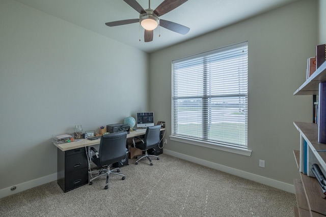 carpeted home office with baseboards and ceiling fan