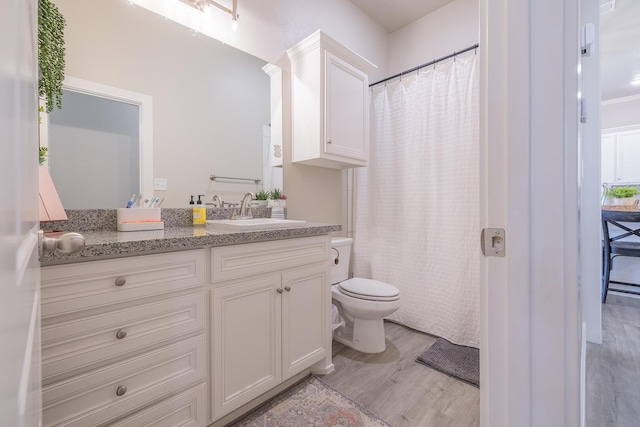 full bath featuring a shower with shower curtain, toilet, vanity, and wood finished floors