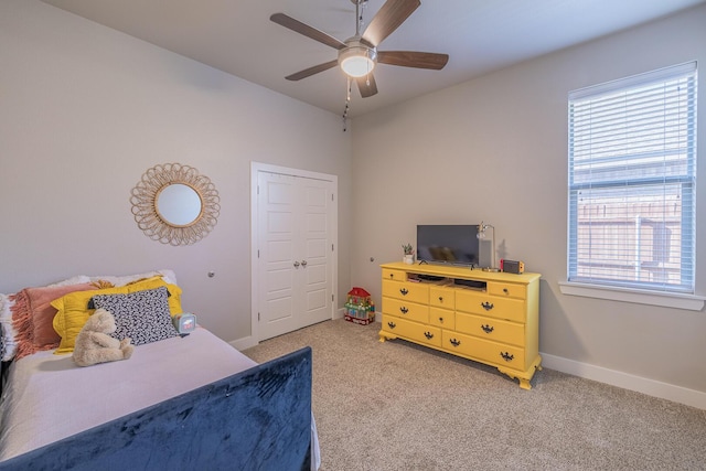 bedroom featuring multiple windows, light colored carpet, baseboards, and ceiling fan