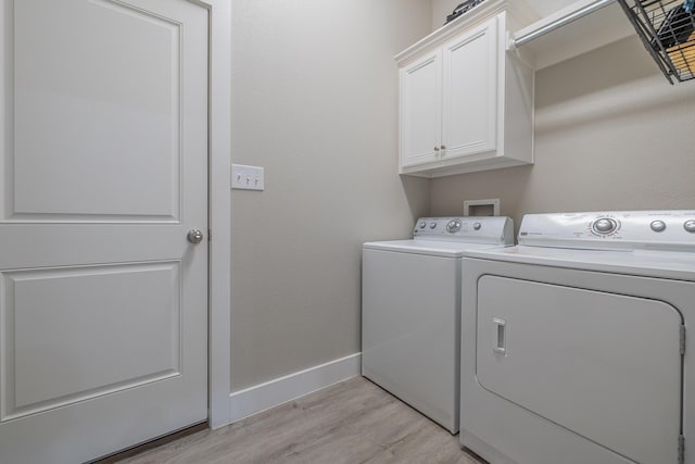 washroom with light wood finished floors, cabinet space, baseboards, and separate washer and dryer