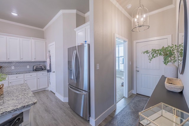 kitchen with stainless steel fridge, light wood-style floors, and white cabinetry